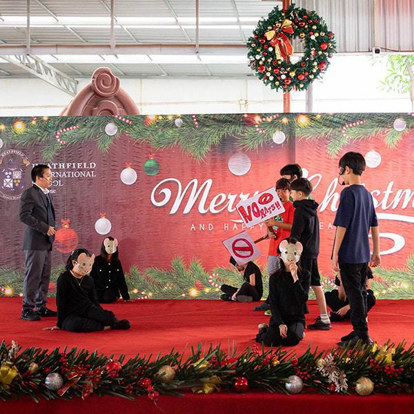 Students enact a dramatic stage performance featuring masks and props, delivering a thought-provoking storyline.