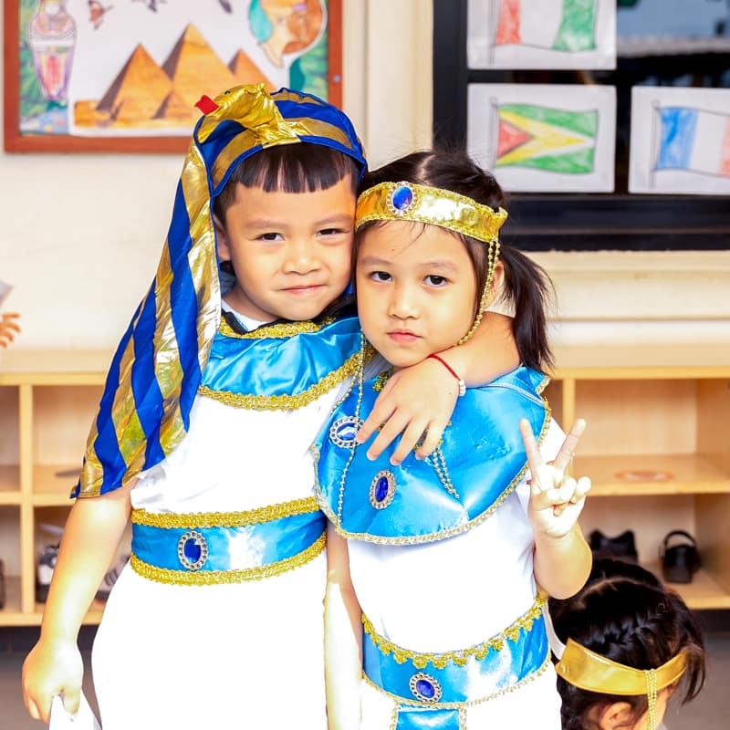 Two children dressed in ancient Egyptian costumes posing together.