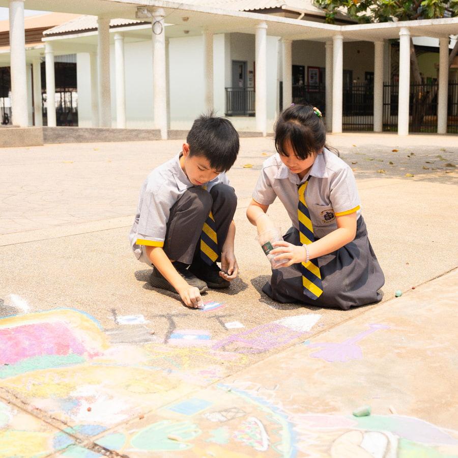 Two students working on chalk art for inclusion week