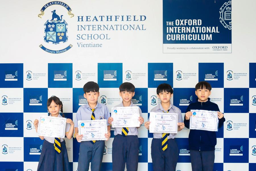 Times Tables Competition winners proudly holding their certificates at Heathfield International School."