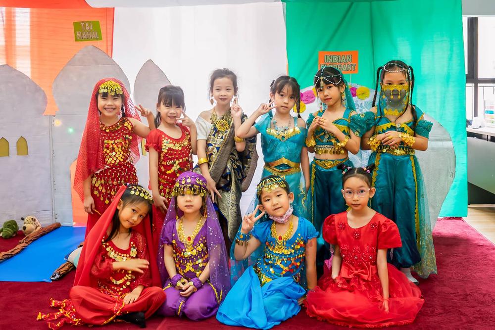 Young students dressed in international clothing holding hands