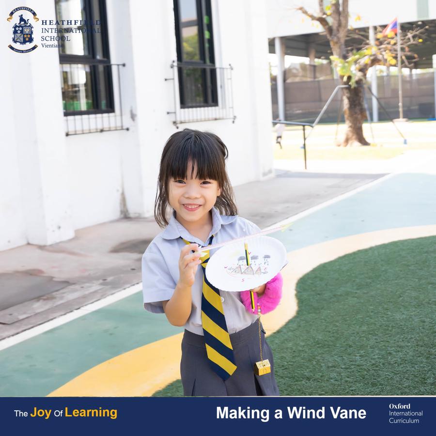 A student proudly holding a handmade wind vane created during a science lesson at Heathfield International School.