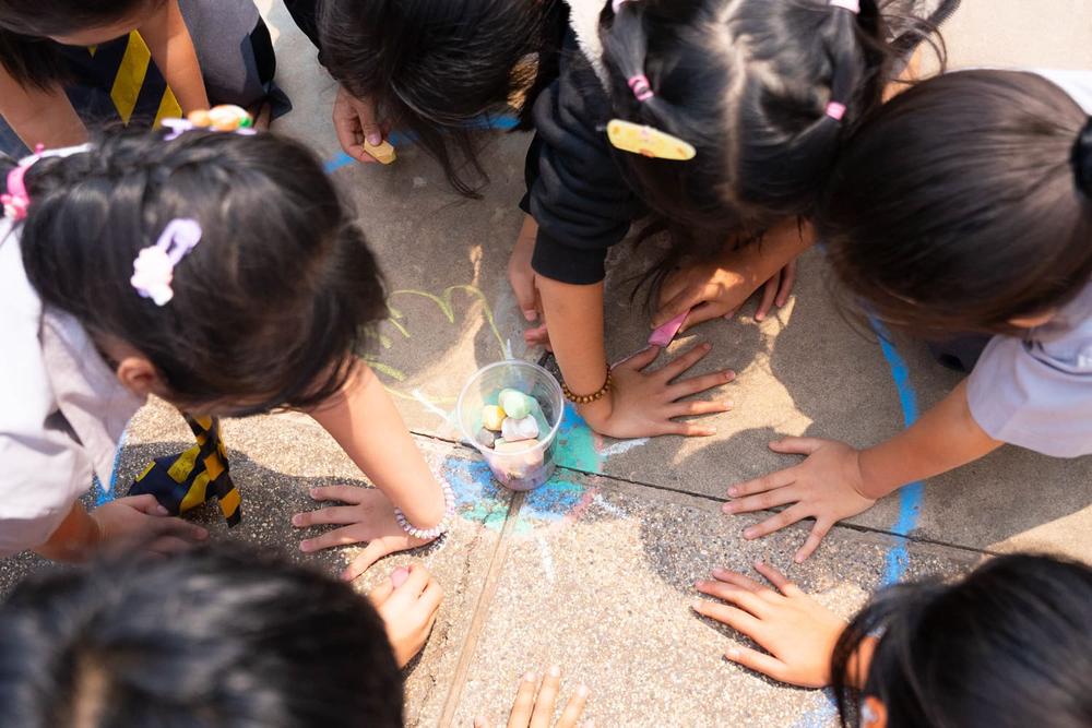 Students outlining their hands with chalk