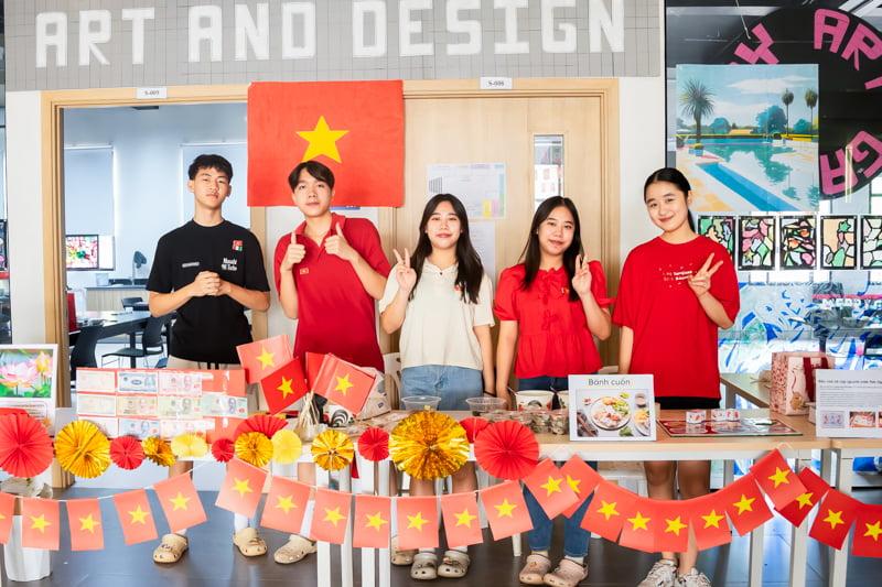 Group of students representing China, standing at a table with Chinese food