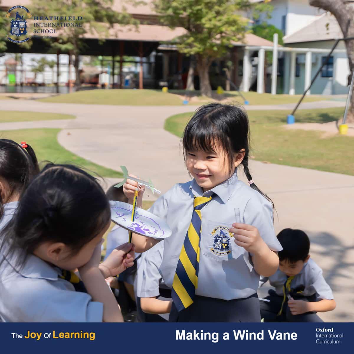 A close-up of students collaborating and adding finishing touches to their wind vane project.