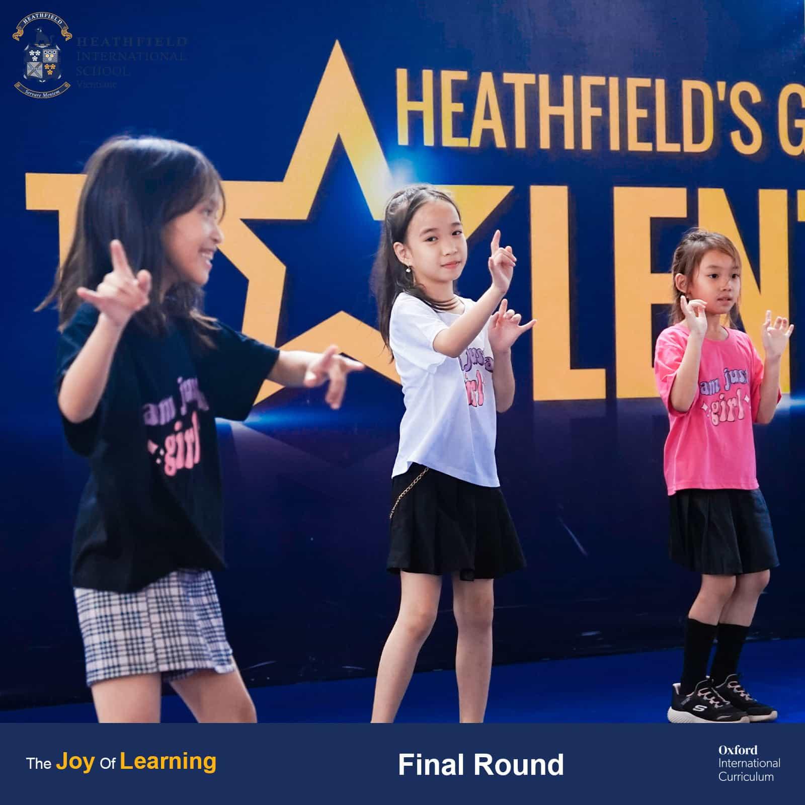 Three participants performing a coordinated dance routine on stage during Heathfield's Got Talent finals.